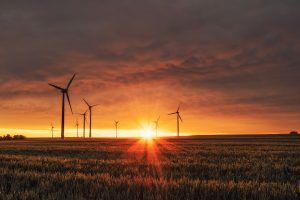 Wind turbines at sunset, illustrating EnergyAustralia’s AWS data centre exit and improved cloud resilience.